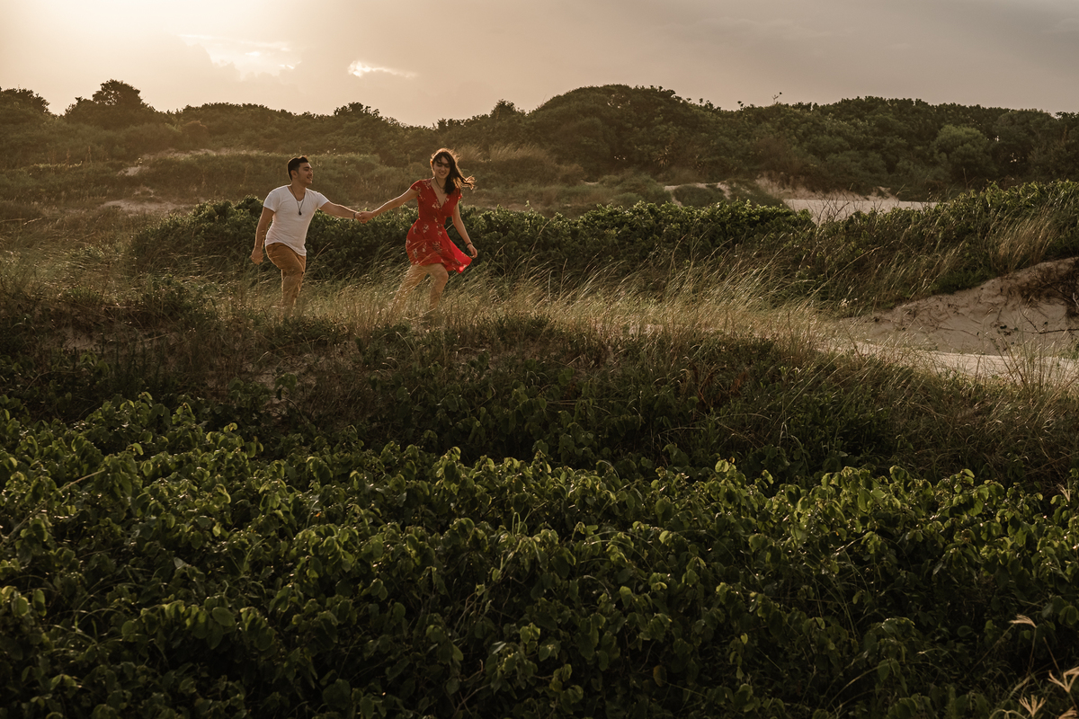 noivos caminhando na areia da praia do campeche em floripa no ensaio pré-casamento