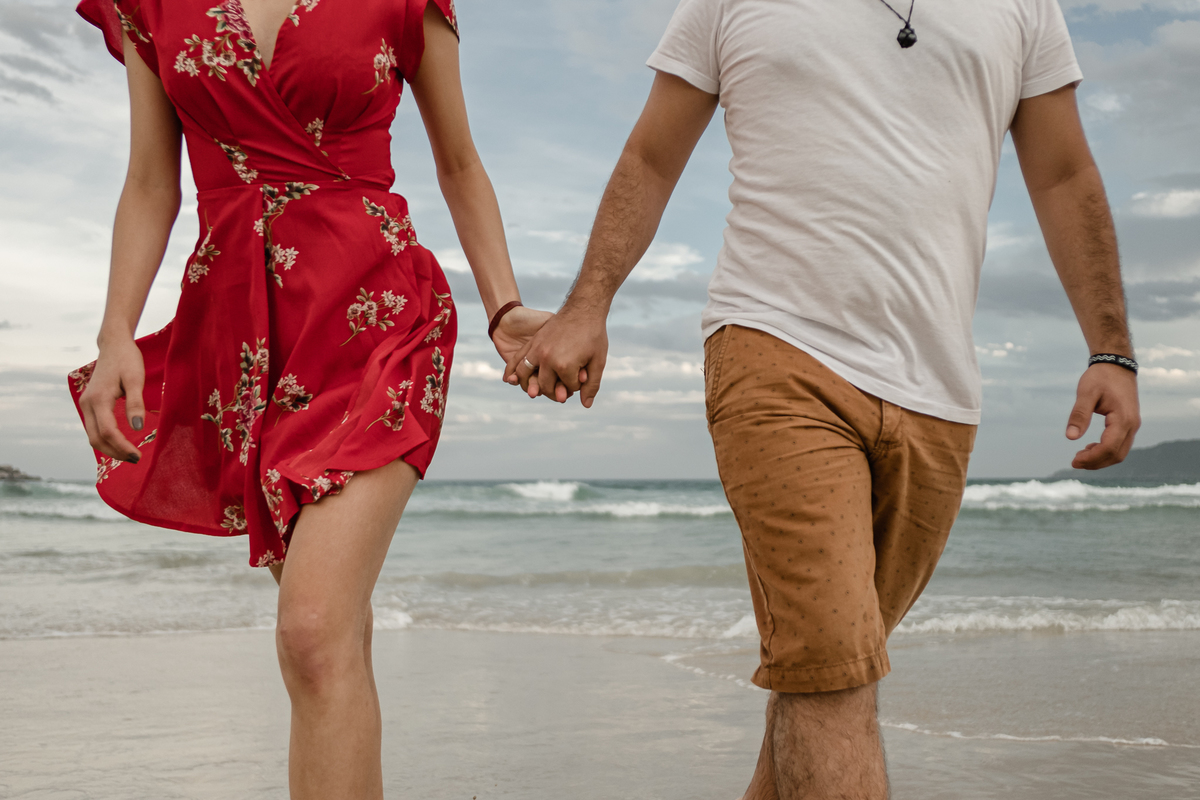 noivos caminhando na areia da praia do campeche em floripa no ensaio pré-casamento