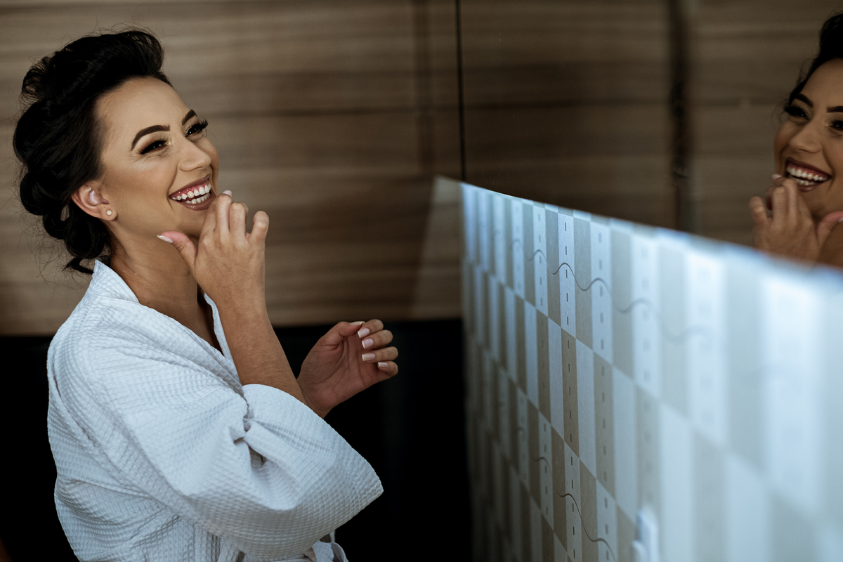 noiva sorrindo em frente ao espelho
