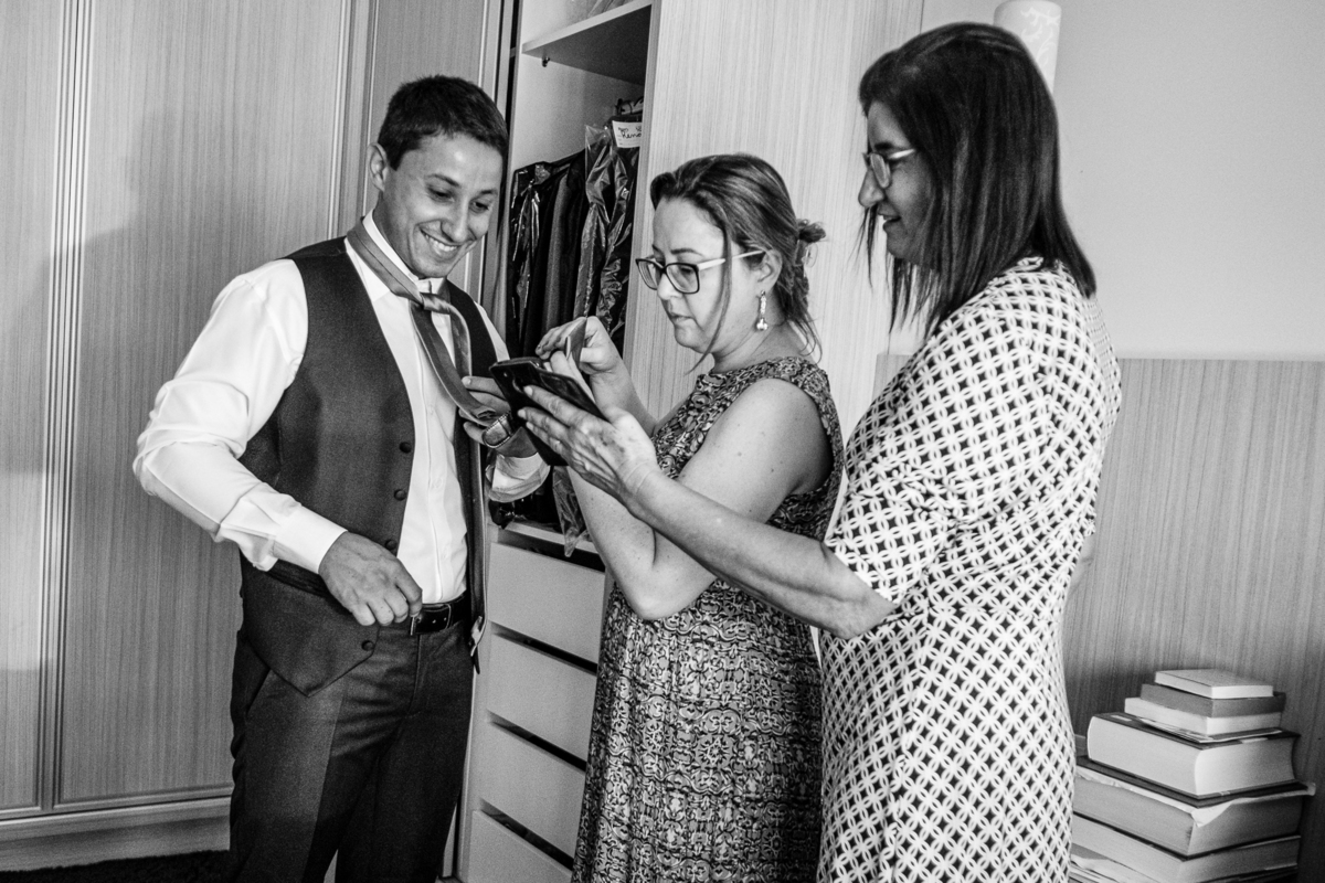 noivo tentando aprender a fazer nó na gravata no making of