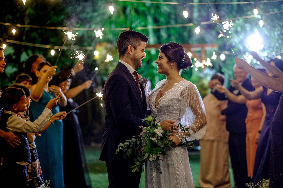 um olhar antes do beijo dos noivos em meio aos convidados com sparkles