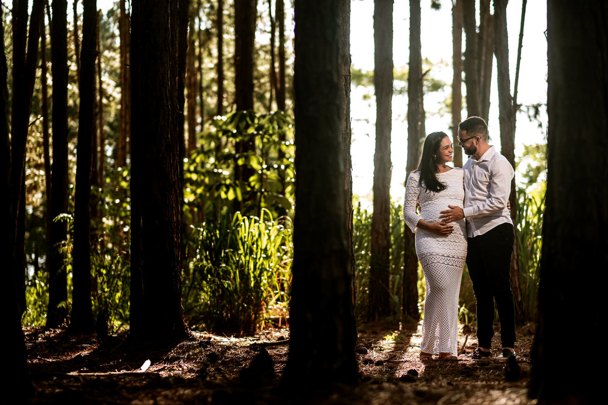 papai e mamãe grávida em meio ás árvores