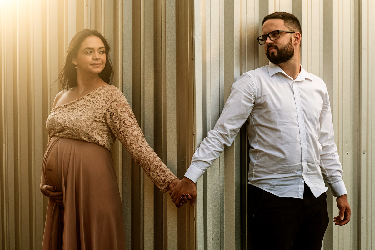 casal gestante de mãos dadas posando para a foto