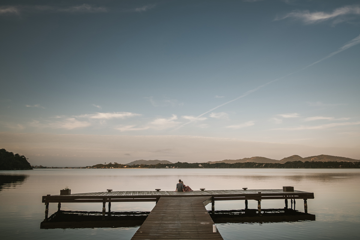 casal sentados em deck a beira da lagoa