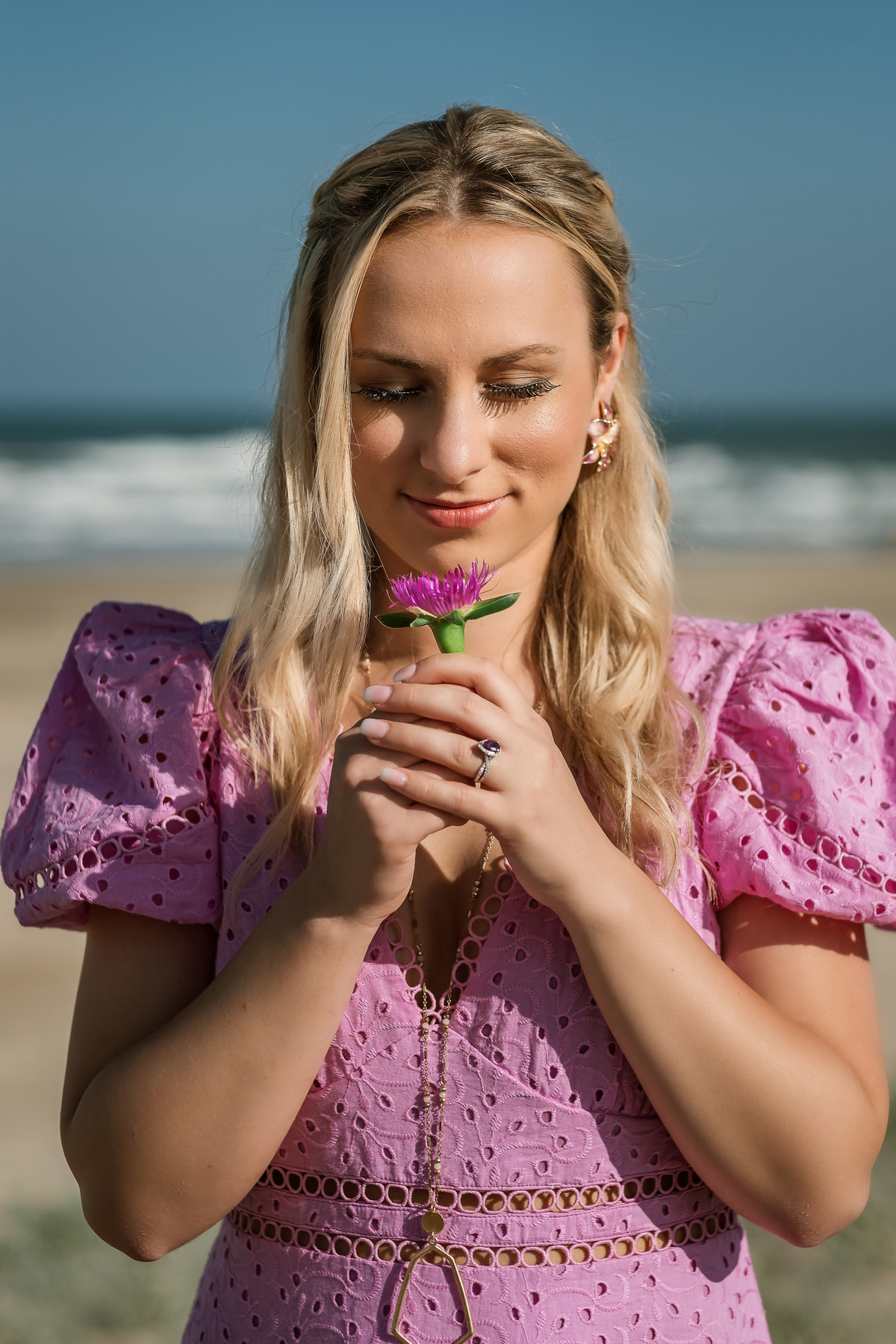 noiva admirando um flor na praia
