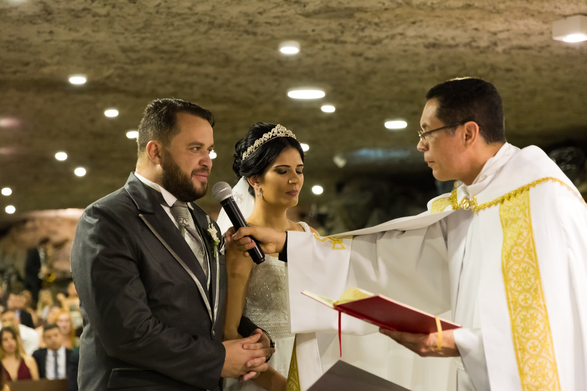 Fotos de Casamento na Gruta Alphaville foto dos noivos com o padre no altar da igreja