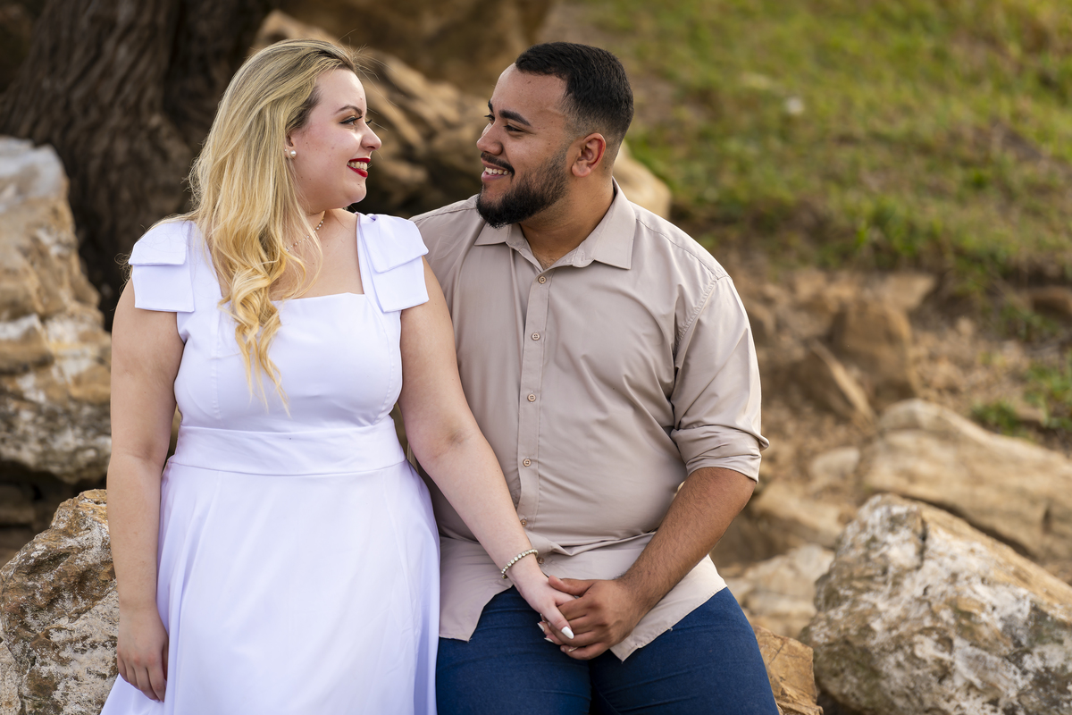 No alto do Morro do Capuava, Kamila e Daniel contemplam o amor que os eleva — tão leve quanto o voo ao fundo., ensaio pré-wedding Alphaville, ensaio fotográfico pré-wedding Morro do Capuava ensaio, fotos de casal ao pôr do sol, pré-wedding com parapente