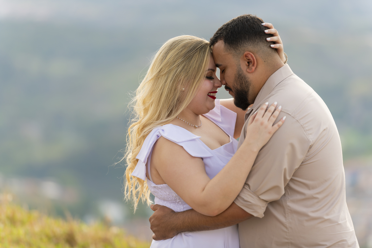 No alto do Morro do Capuava, Kamila e Daniel contemplam o amor que os eleva — tão leve quanto o voo ao fundo., ensaio pré-wedding Alphaville, ensaio fotográfico pré-wedding Morro do Capuava ensaio, fotos de casal ao pôr do sol, pré-wedding com parapente