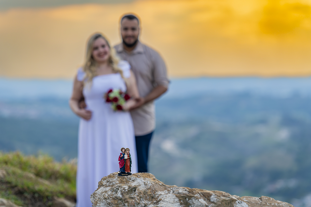 No alto do Morro do Capuava, Kamila e Daniel contemplam o amor que os eleva — tão leve quanto o voo ao fundo., ensaio pré-wedding Alphaville, ensaio fotográfico pré-wedding Morro do Capuava ensaio, fotos de casal ao pôr do sol, pré-wedding com parapente