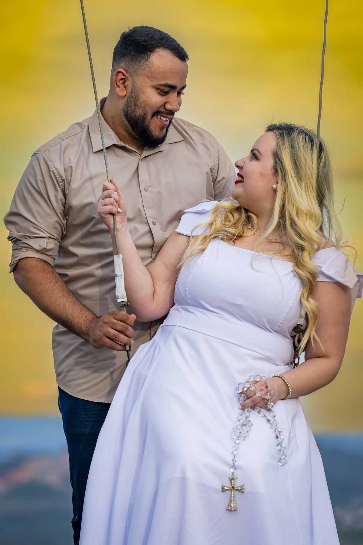 No alto do Morro do Capuava, Kamila e Daniel contemplam o amor que os eleva — tão leve quanto o voo ao fundo., ensaio pré-wedding Alphaville, ensaio fotográfico pré-wedding Morro do Capuava ensaio, fotos de casal ao pôr do sol, pré-wedding com parapente