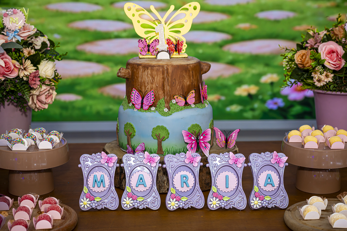 Vista aproximada do bolo de aniversário com topo de borboleta amarela, decoração de festa infantil em Alphaville.