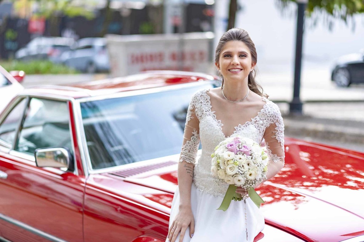 Fotografia de casamento em alphaville no edifício Vogue Alphaville Noiva com buquê encostada no carro