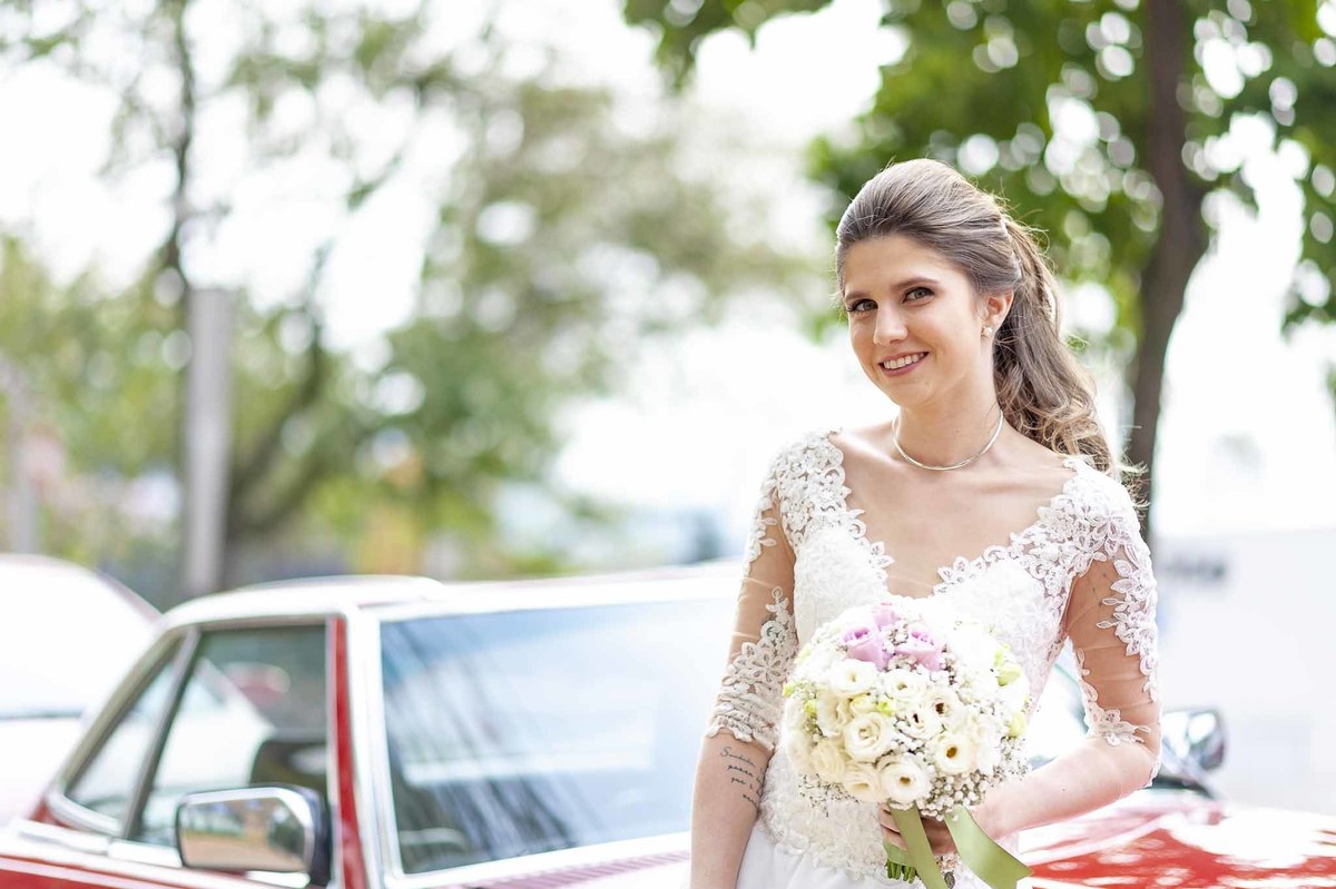 Fotografia de casamento em alphaville no edifício Vogue Alphaville Noiva com buquê encostada no carro