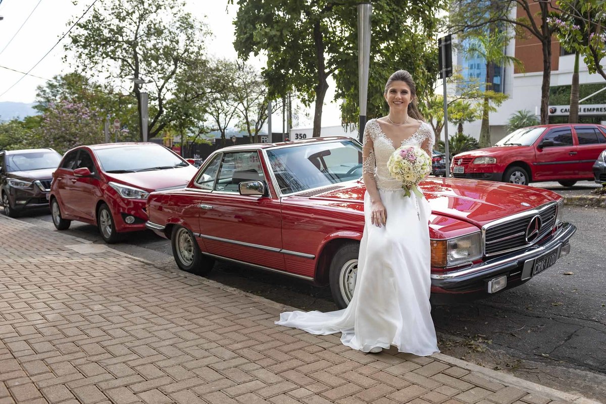 Fotografia de casamento em alphaville no edifício Vogue Alphaville Noiva com buquê encostada no carro