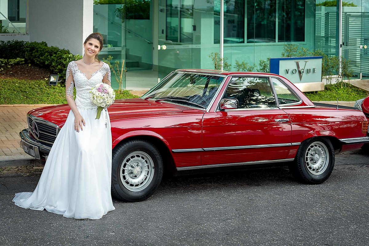 Fotografia de casamento em alphaville no edifício Vogue Alphaville Noiva com buquê encostada no carro