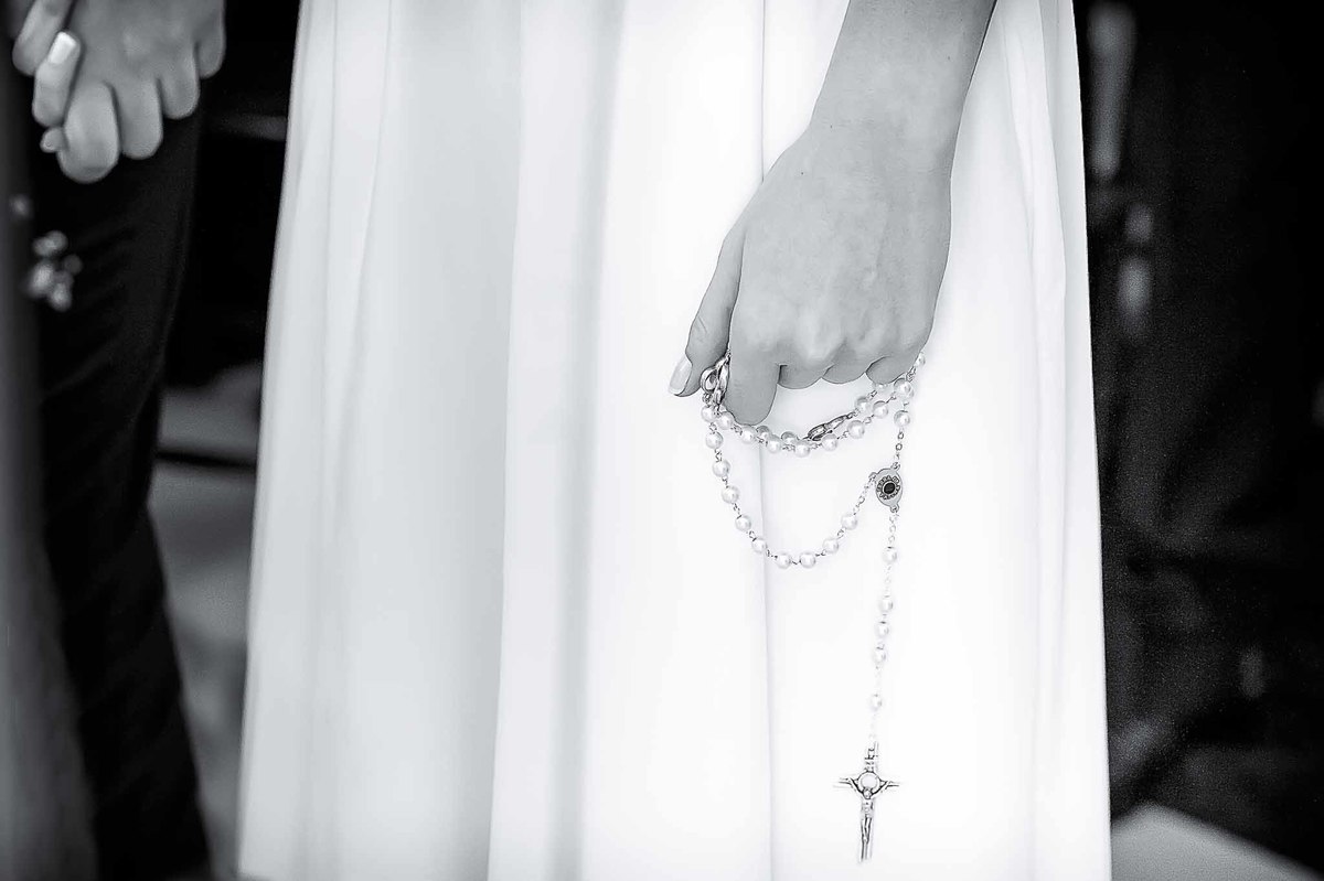 Fotografia de casamento em alphaville no edifício Vogue Alphaville Noiva com o terço na mão em preto e branco