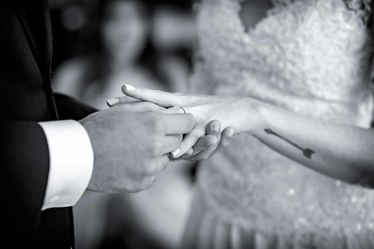 Fotografia de casamento em alphaville no edifício Vogue Alphaville noivo colocando a aliança no dedo da noiva