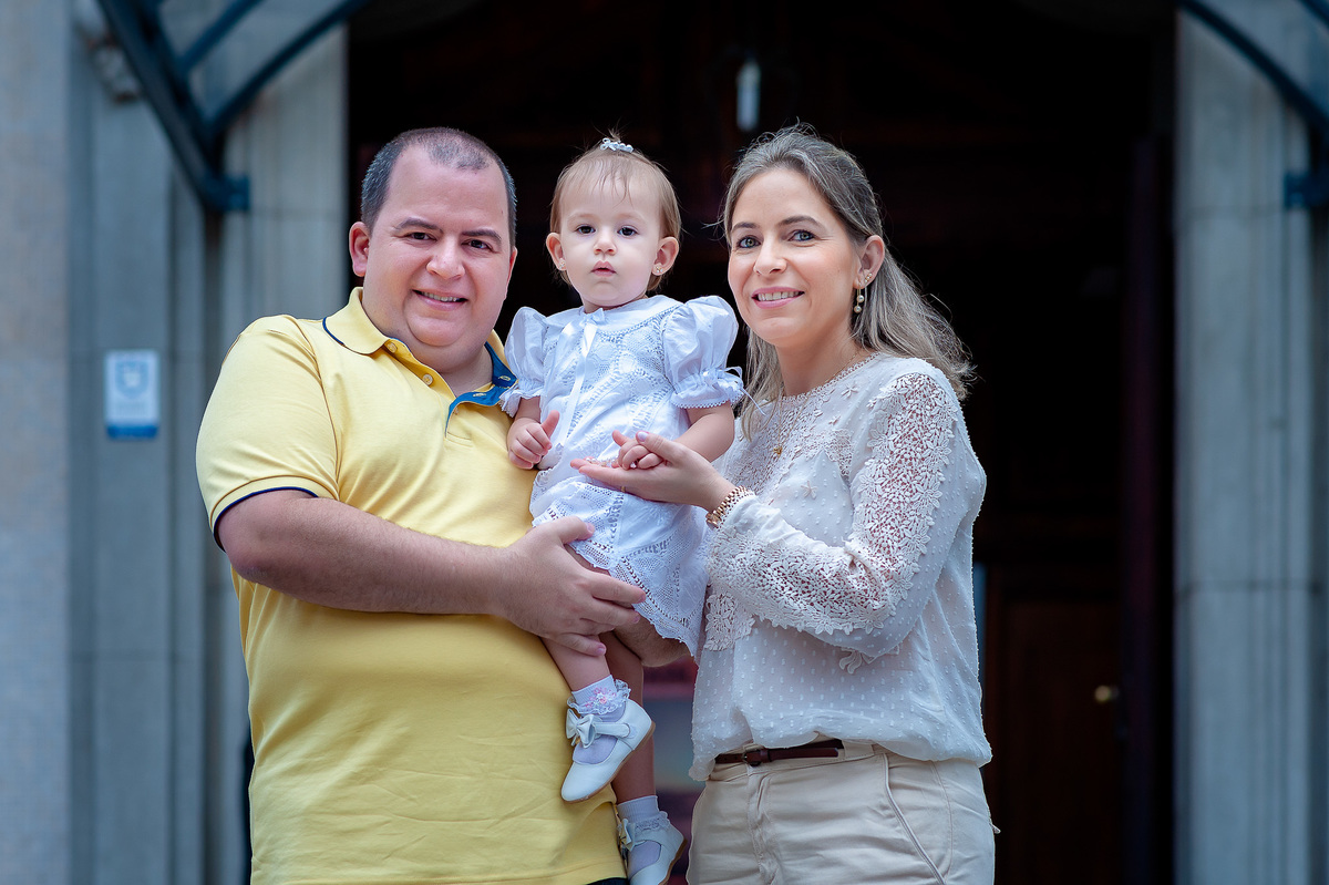Fotografia de batizado na Igreja Nossa Senhora do Brasil. Foto  de batizado Foto externa de pais com a criança após o batizado na Igreja Nossa Senhora do Brasil - São Paulo. Foto  de batizado na Igreja Nossa Senhora do Brasil. Batizado nossa senhora