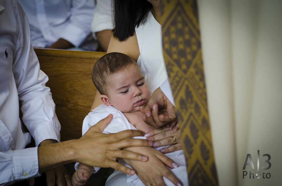 fotografia de batizado em alphaville, fotografia de batizado na igreja nossa senhora de lourdes alphaville, foto de batizado, foto padre ungindo criança em alphaville
