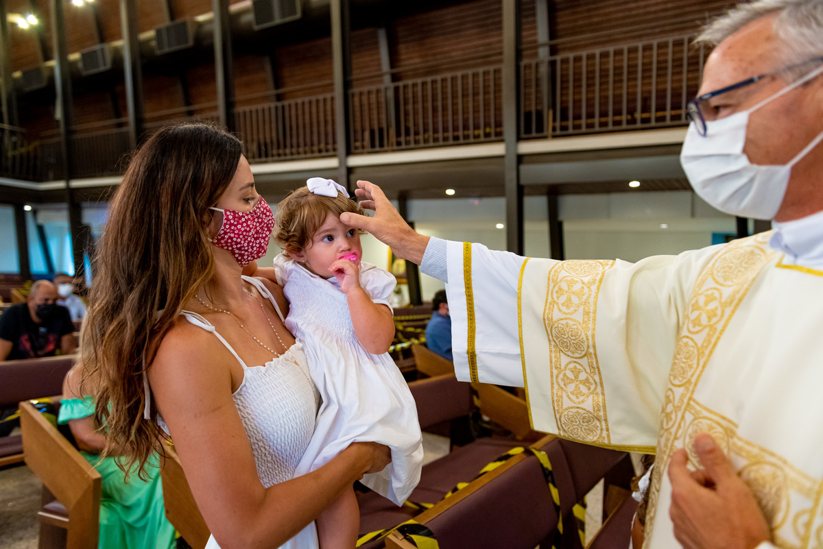Fotografia de batizado na igreja Nossa Senhora de Lourdes Alphaville, fotografia de batizado em alphaville, batizado de menina, batizado católico de menina, batizado católico de meninas, batizado triplo de meninas, padre fazendo o sinal da cruz