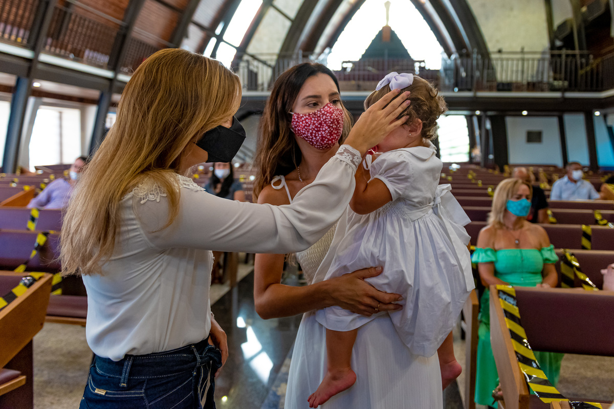 Fotografia de batizado na igreja Nossa Senhora de Lourdes Alphaville, fotografia de batizado em alphaville, batizado de menina, batizado católico de menina, batizado católico de meninas, batizado triplo de meninas, pais fazendo o sinal da cruz