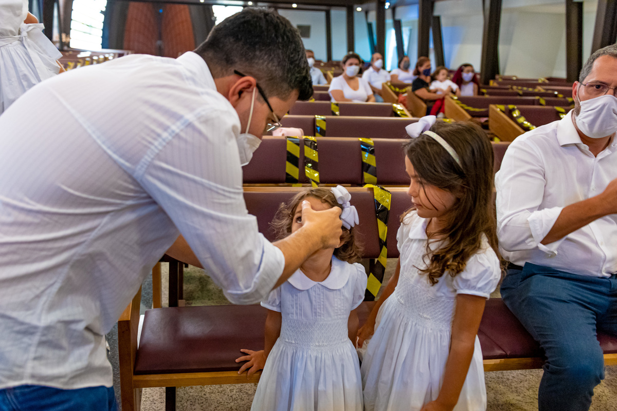 Fotografia de batizado na igreja Nossa Senhora de Lourdes Alphaville, fotografia de batizado em alphaville, batizado de menina, batizado católico de menina, batizado católico de meninas, batizado triplo de meninas, pais fazendo o sinal da cruz