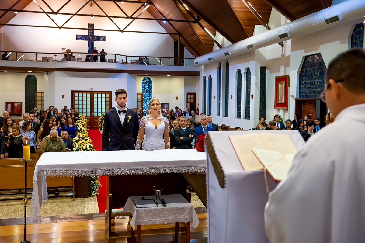 padre com noivos no altar
