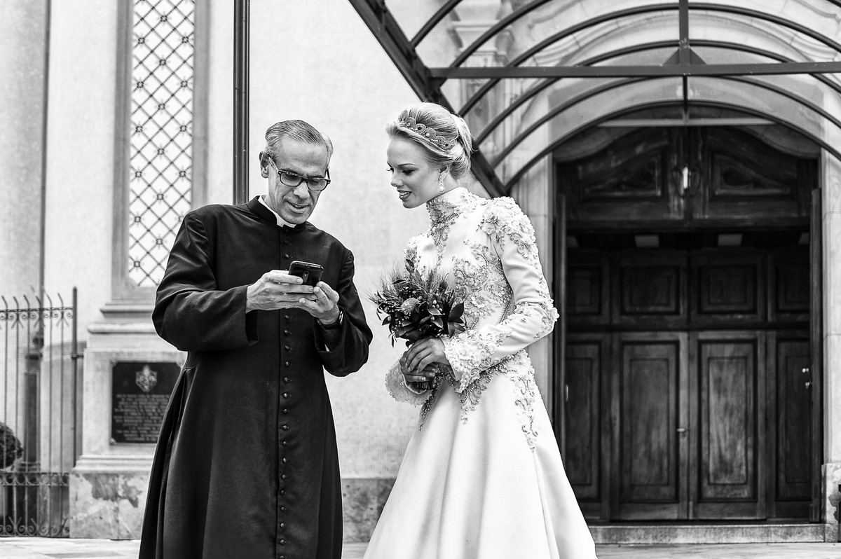 coiva conversando com o padre na porta da igreja