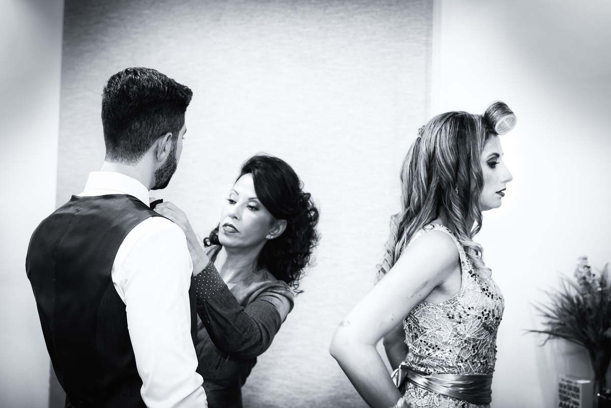 mãe arrumando o noivo em casa