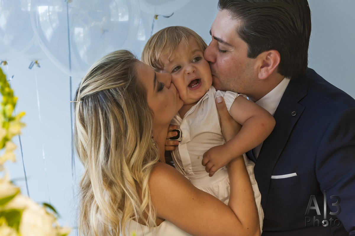 fotografia de batizado em são paulo. fotografia de batizado na igreja nossa senhora do brasil. pais beijando o filho