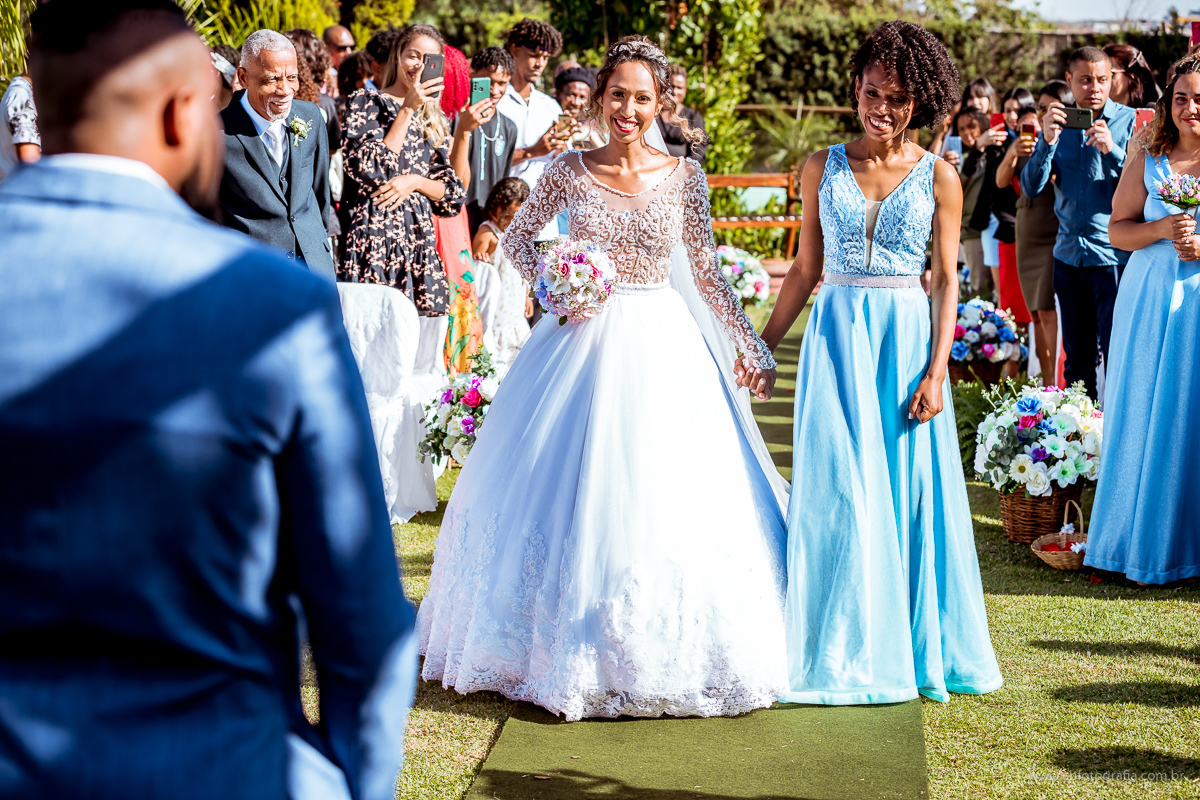 Entrada da noiva na cerimonia, foto de casamento Chácara Joquebede, noiva entrando sorrindo, noiva sorrindo, noiva olhando para o noivo, foto de noiva entrando 