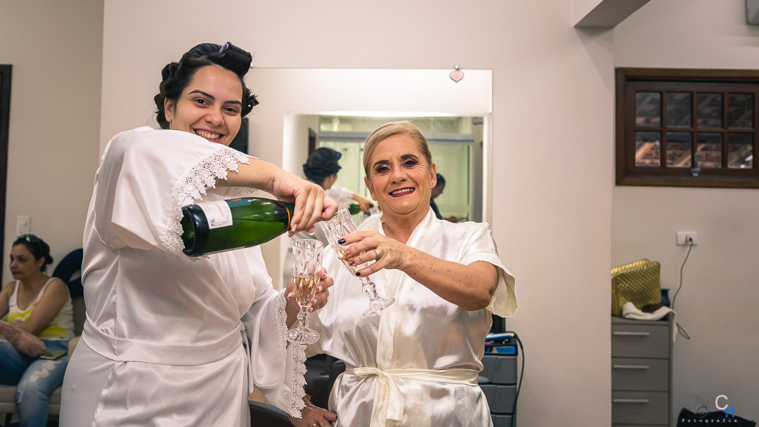 Fotos do making off da noiva, fotos da noiva se arrumando, fotos da noiva minutos antes do casamento, foto da noiva tomando champanhe com sua mae 