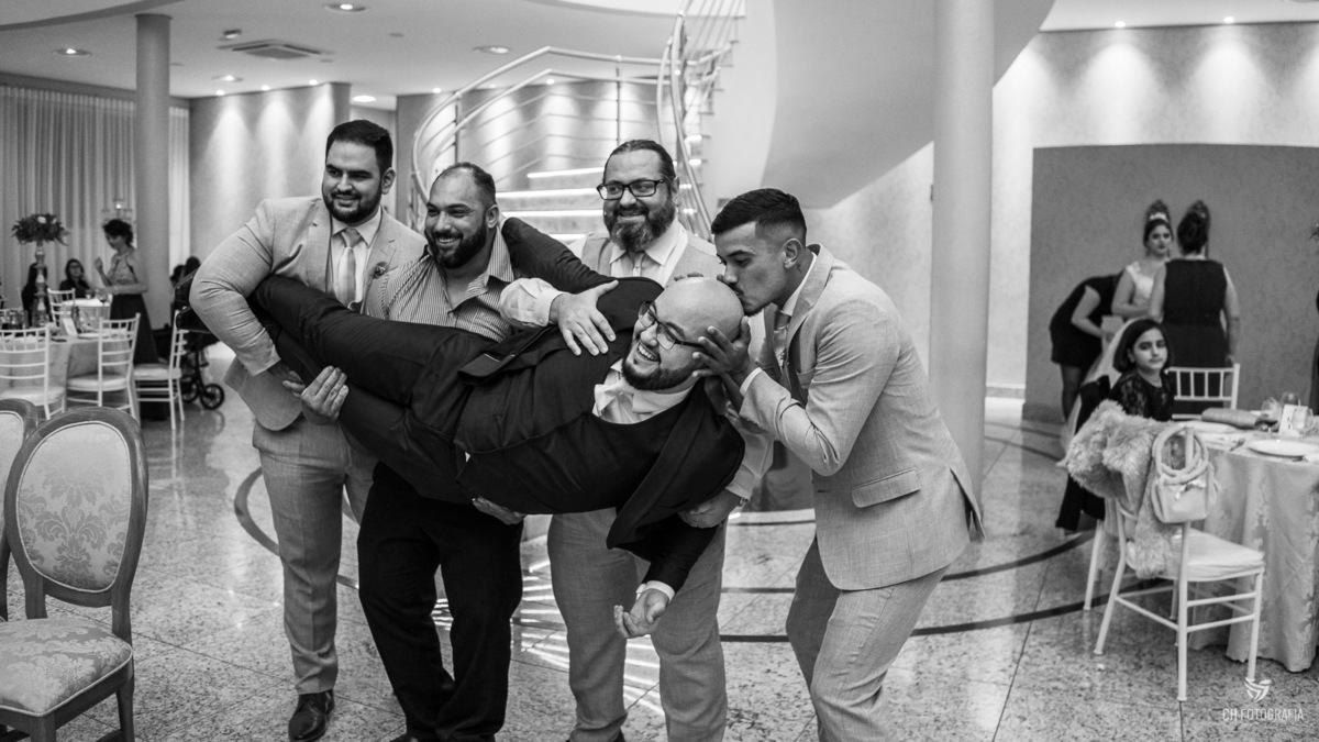 Foto do padrinho beijando o noivo Le Partie Comemorações