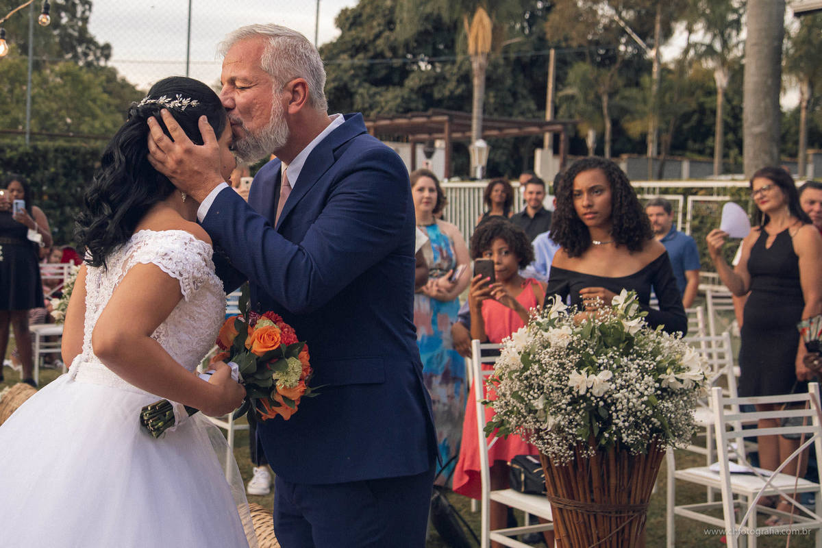 Entrada da noiva na cerimonha realizada na Chácara Recanto Realize, pai beijando a noiva na entrada 