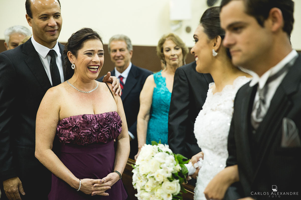 padrinhos de casamento dos noivos sorrindo e emocionados com a entrada da noiva
