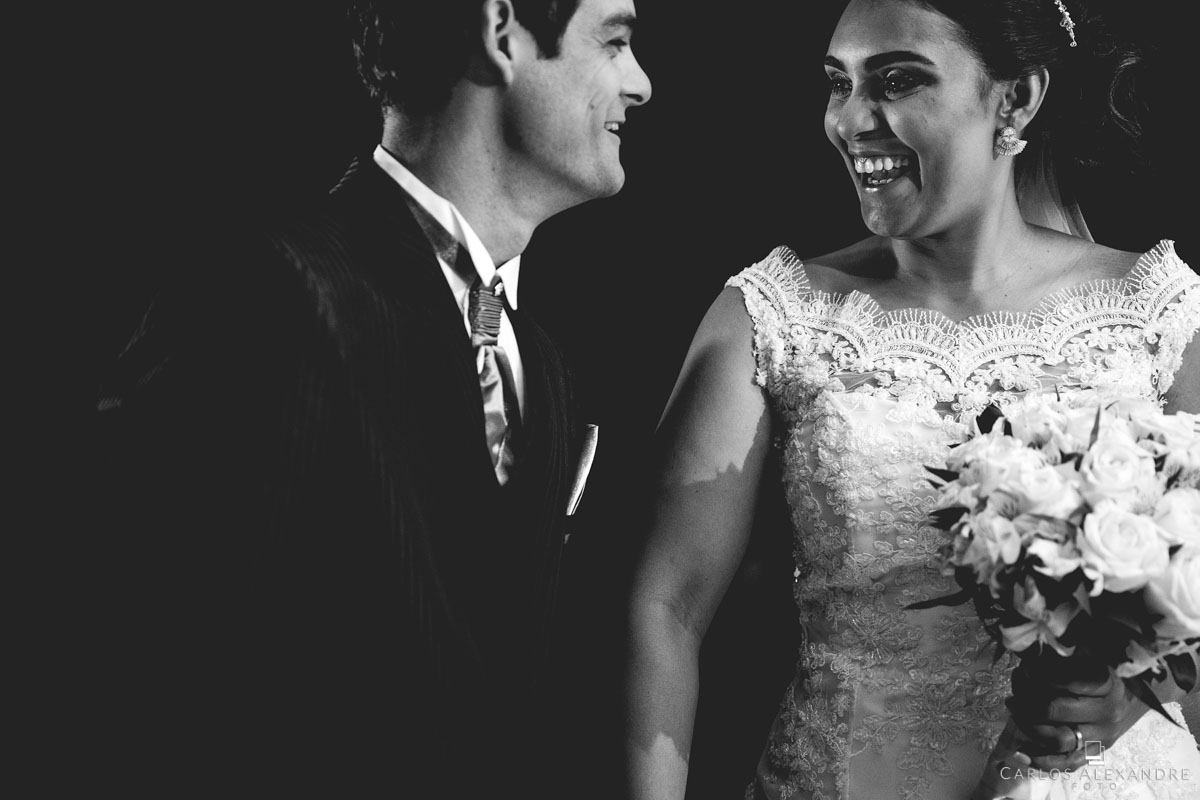 casal se olhando e sorrindo, felizes e realizados foto em pb em sua festa no casamento fotografado em três corações MG, Sul de Minas pelo fotógrafo de casamentos Carlos Alexandre