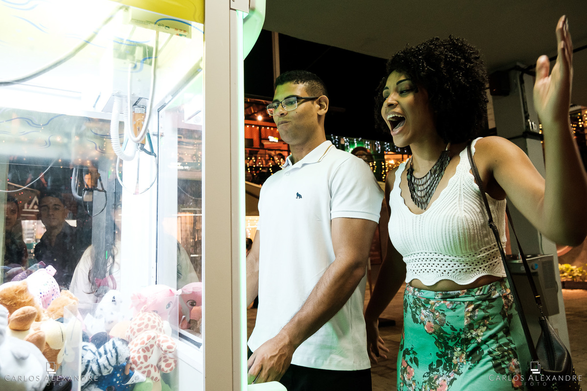 ensaio de casal no villa conteiner casal jogando em máquina de pelúcia