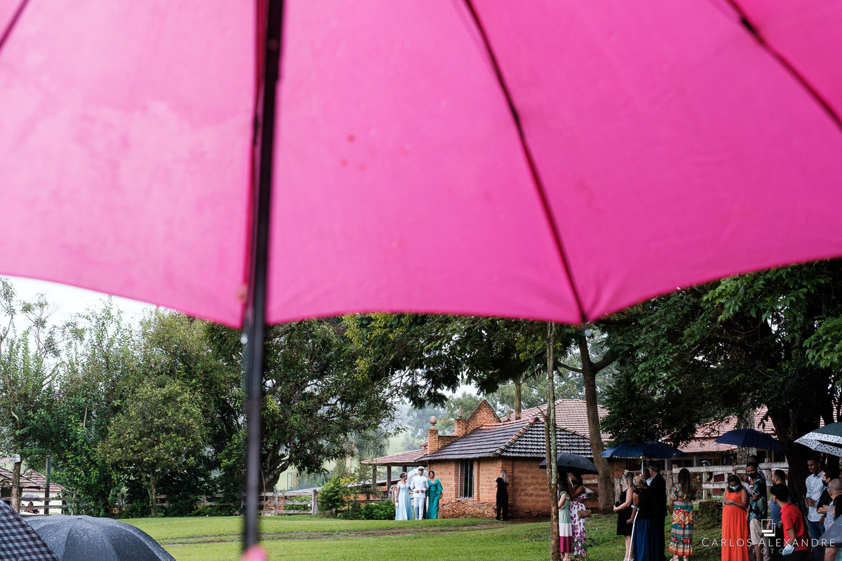 entrada do noivo com um guarda chuva rosa na frente