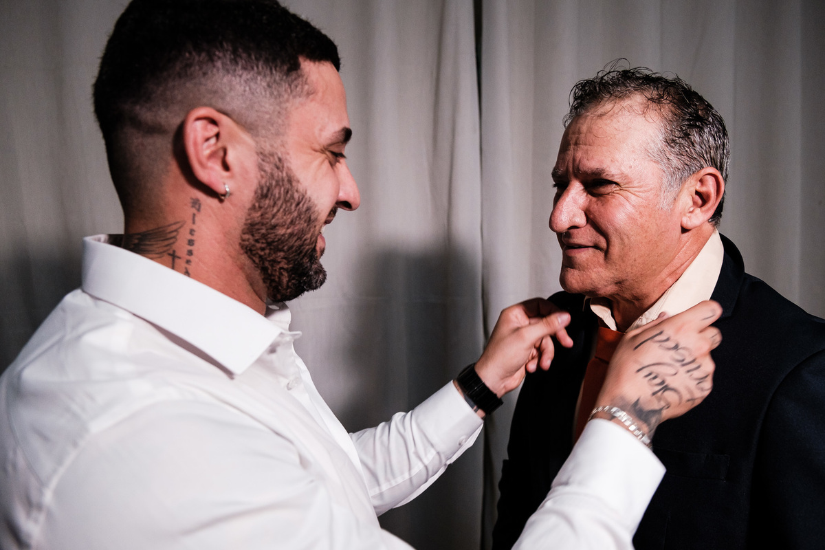 filho ajustando a gravata do pai no making of