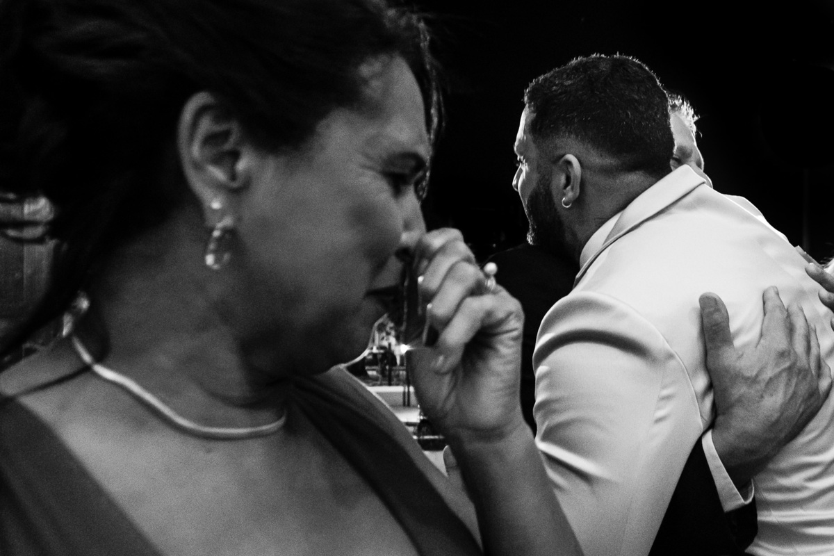 mae emocionada enquanto pai abraça filho