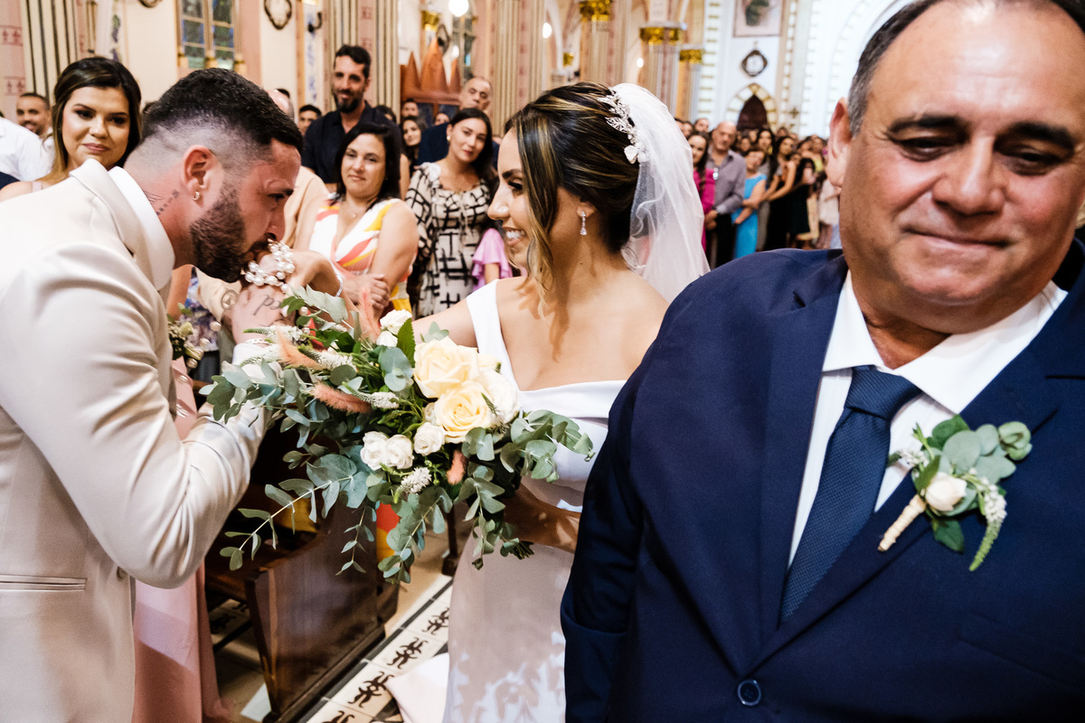 pai saindo de cena com noivo beijando a mão de sua noiva
