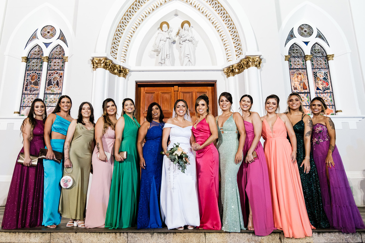 noiva madrinhas de cores sortidas perfiladas em frente a igreja