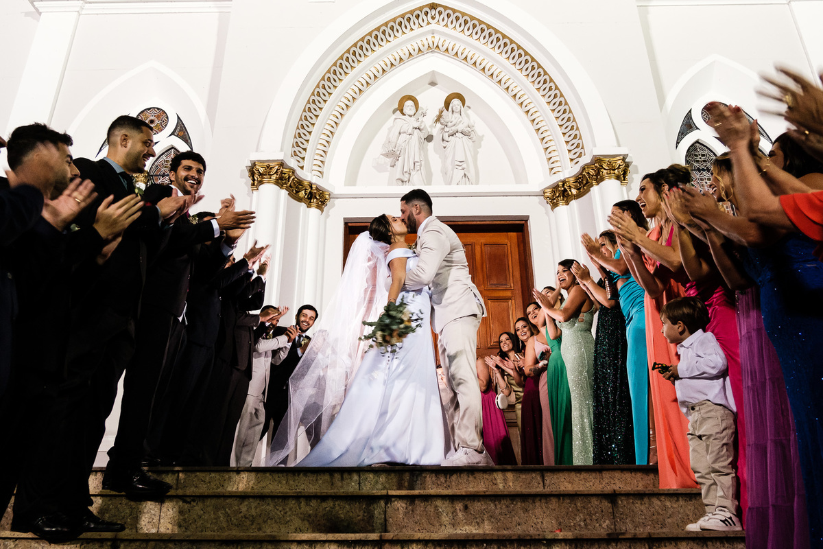 padrinhos e madrinhas aplaudindo o casal na saída do casamento