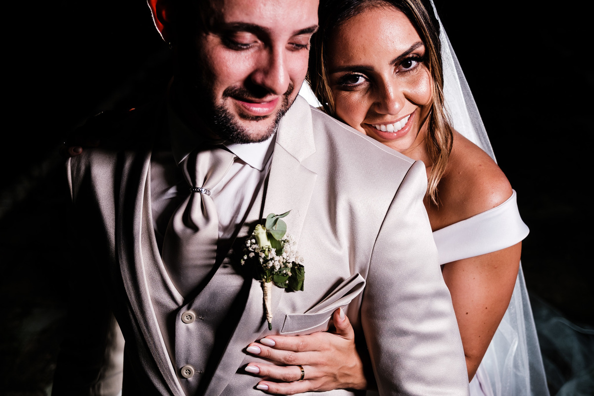 noiva abraçando seu noivo por trás e sorrindo