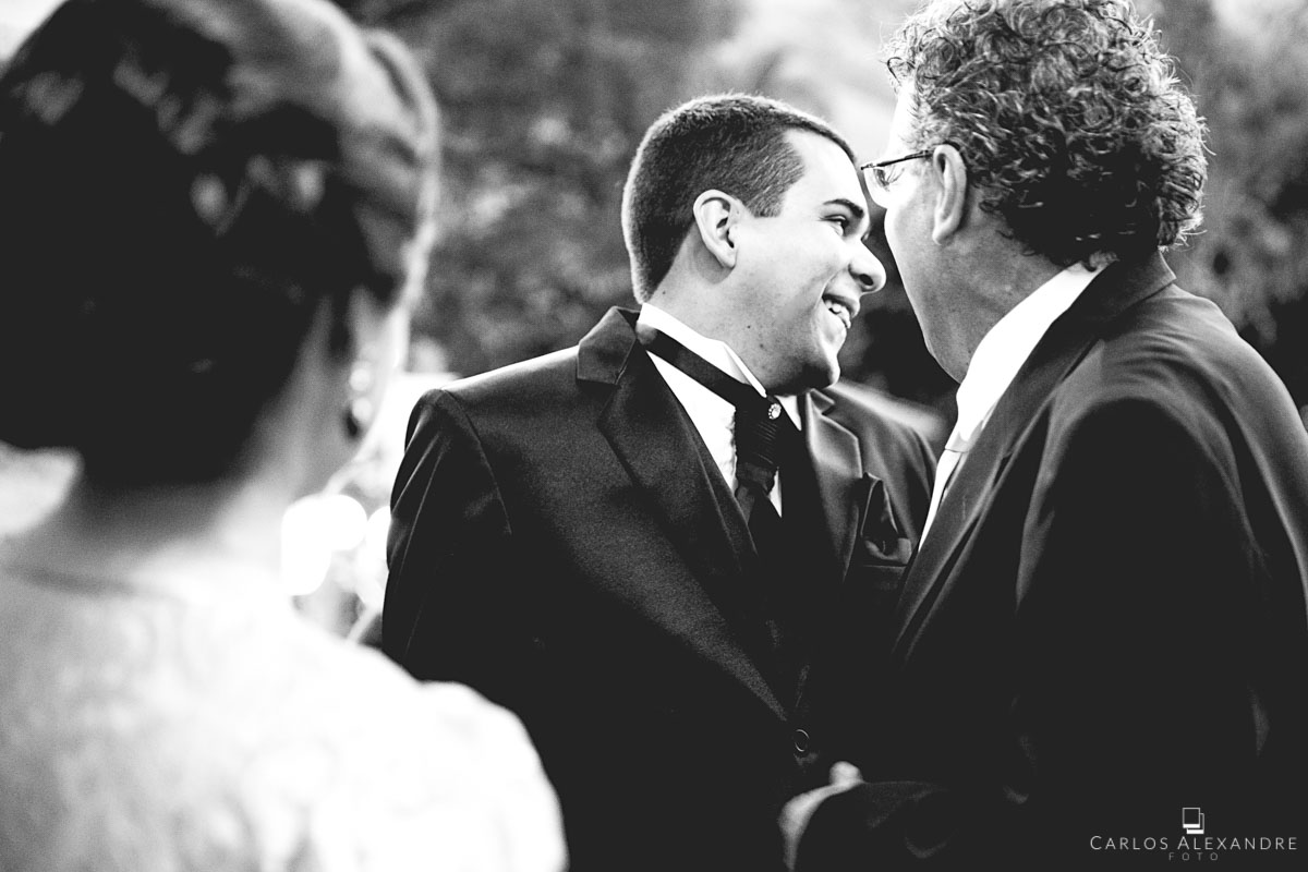noivo recebendo e conversando alegre e sorrindo com os padrinhos e convidados antes do casamento fotografado por carlos alexandre foto fotógrafo em três corações sul de minas