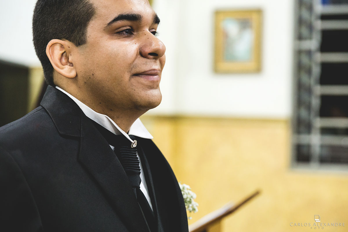 noivo emocionado e chorando ao ver sua noiva adentrando a porta da igreja fotografado por carlos alexandre foto fotógrafo em três corações sul de minas