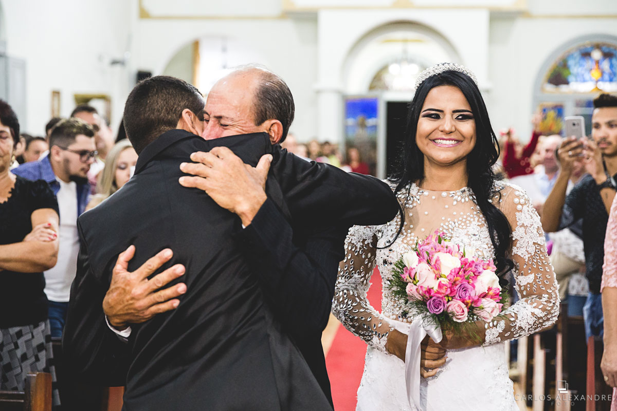 pai dando um forte abraço em seu genro e pedindo para que cuide bem de sua filha querida fotografado por carlos alexandre foto fotógrafo em três corações sul de minas
