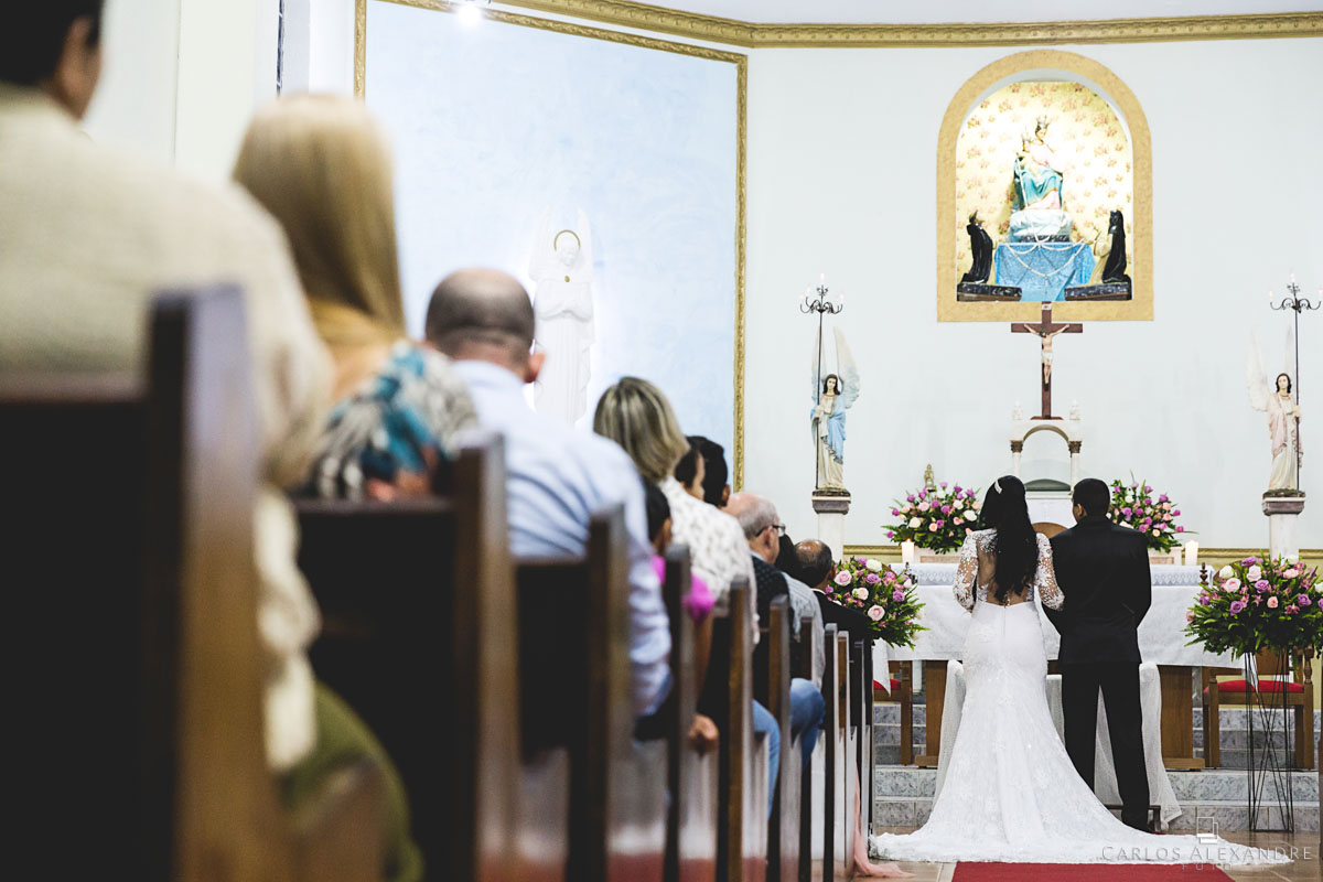 início do corredor da igreja com os noivos no altar fotografado por carlos alexandre foto fotógrafo em três corações sul de minas
