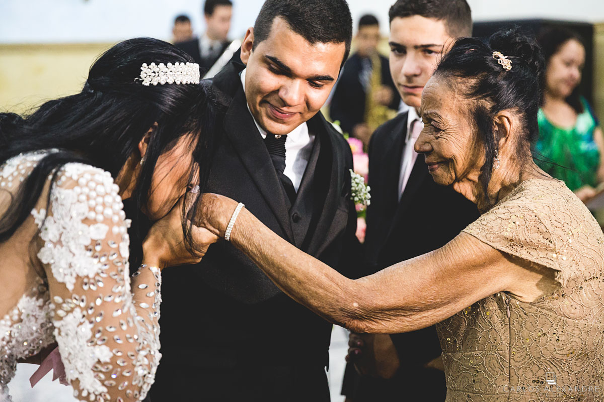 noiva recebendo e dando um beijo nas mãos de sua avó porta aliança fotografado por carlos alexandre foto fotógrafo em três corações sul de minas