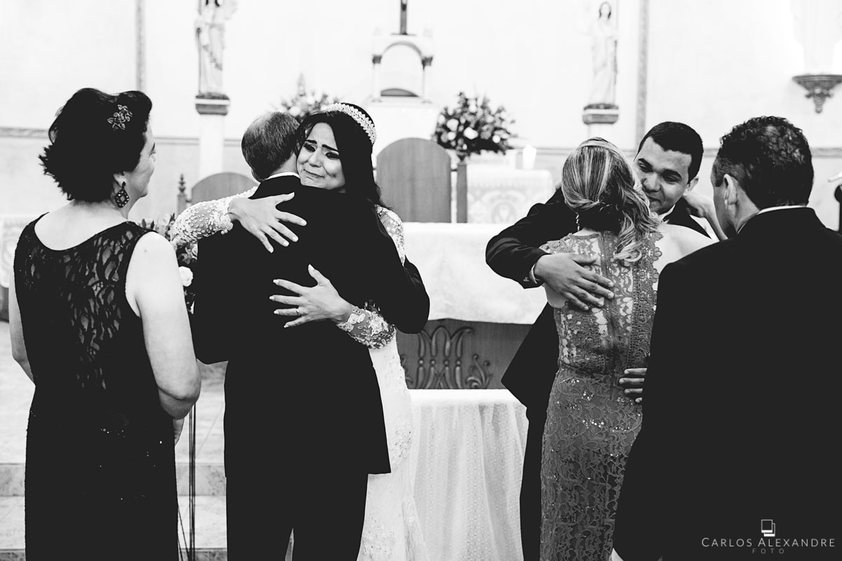 pais e filhos emocionados com o término do casamento e início de uma nova família perante deus fotografado por carlos alexandre foto fotógrafo em três corações sul de minas